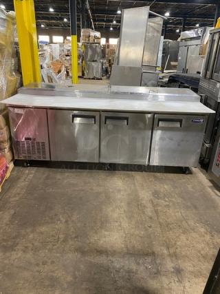 Grista By AdmiralCraft Commercial Stainless Steel 3 Door Refrigerated Mega Top Pizza Prep Table! With Removable Cutting Board! With Poly Coted Wire Racks! Model: GRPZ-3D SN: 6926410821041006! On Casters! - Item #1192389