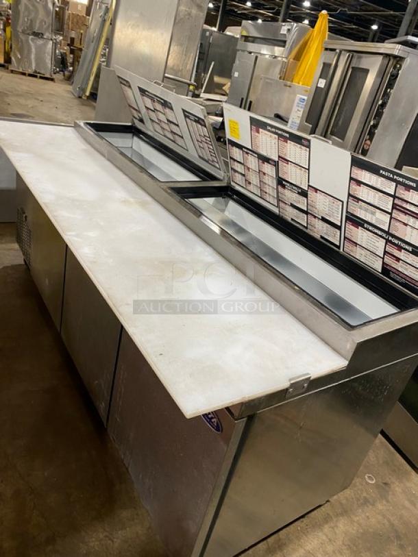 Commercial sandwich prep table with dual refrigerated sections, stainless steel finish, integrated cutting board, visible menu guides.