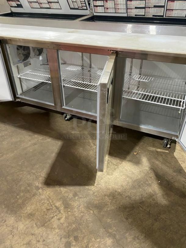 Commercial undercounter refrigerator, stainless steel, with two glass doors and wire shelves, on wheels, in good condition.