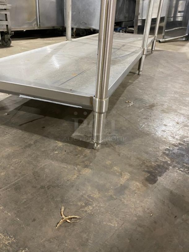 Stainless steel commercial kitchen work table with lower shelf. Sturdy design, good condition, suitable for heavy-duty use.