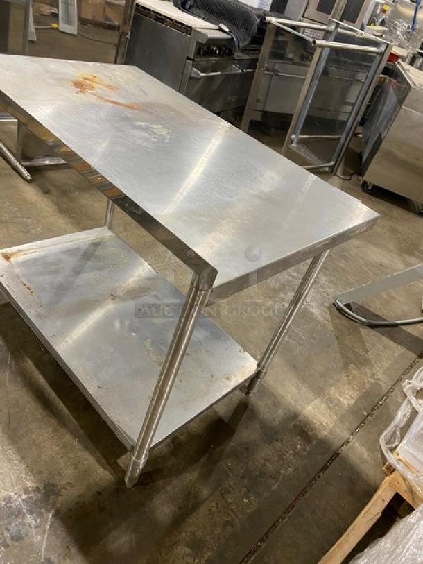 Stainless steel kitchen prep table with rust spots, two-tier design, durable metal construction, used condition.