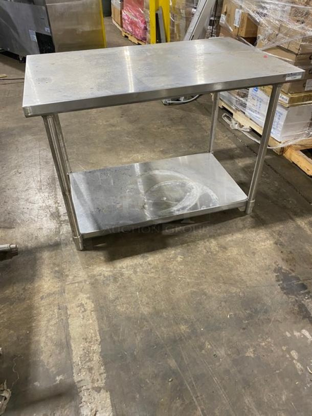 Stainless steel worktable with bottom shelf, commercial grade, clean surface, sturdy condition, ideal for kitchen use.