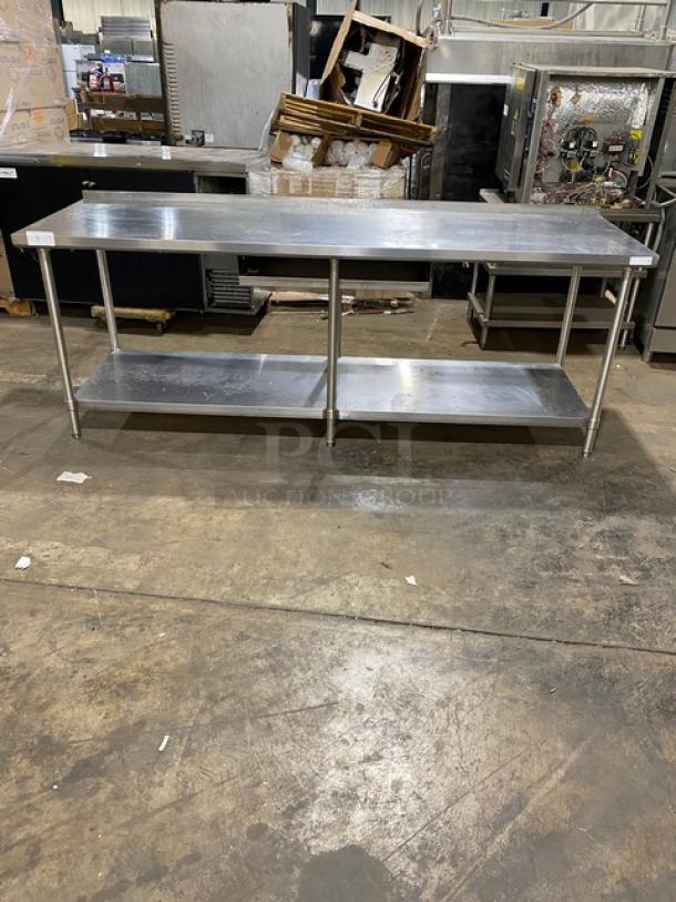 Stainless steel work table with lower shelf, in good condition. Ideal for industrial or commercial kitchens, sturdy and spacious.