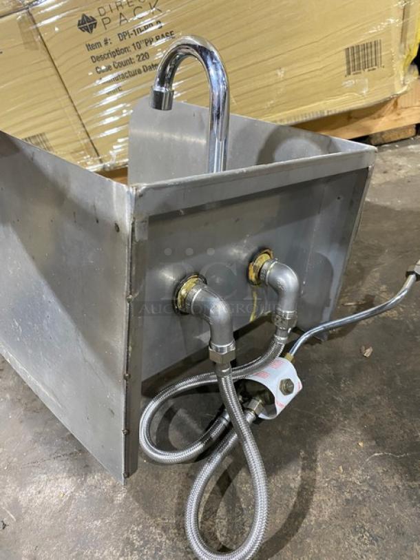 Stainless steel commercial sink with chrome faucet, dual flexible hoses. Good condition. Ideal for industrial kitchen use.