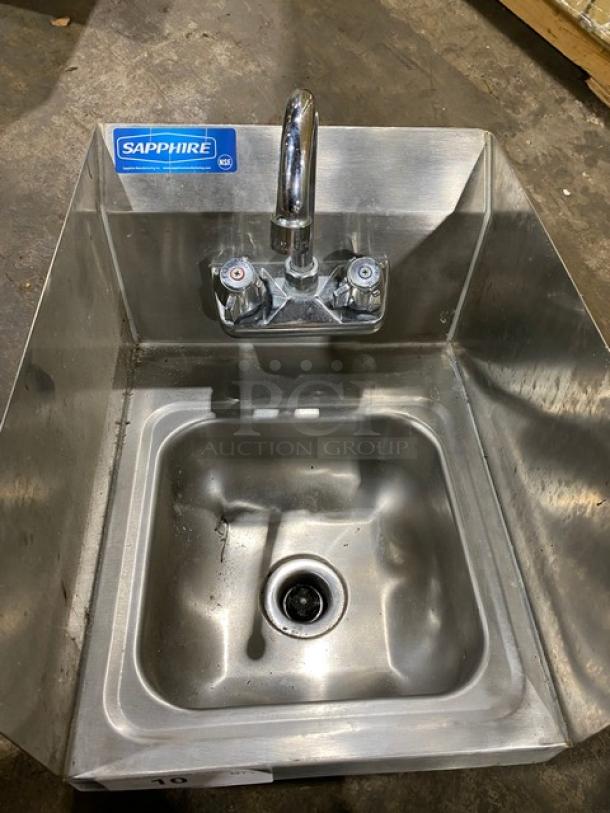 Sapphire stainless steel wall-mounted sink with dual-handle faucet, used condition, visible brand label.