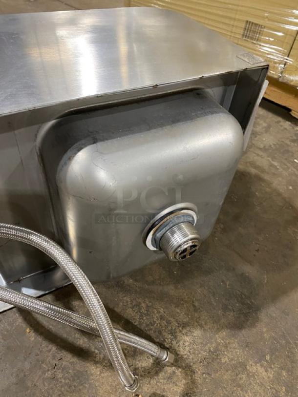 Stainless steel commercial kitchen sink with attached hoses and drain assembly. Excellent condition, ready for installation.