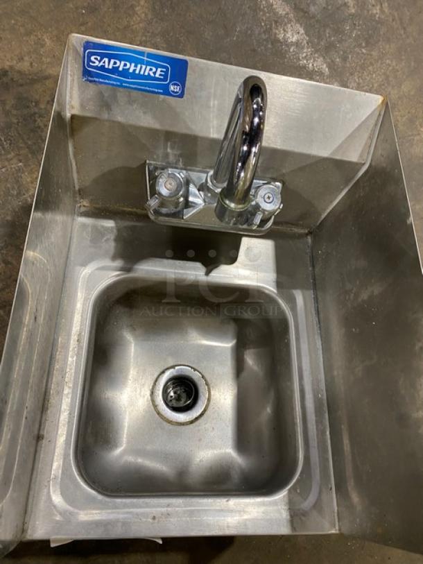 Stainless steel Sapphire sink with faucet, NSF label, rectangular basin, in used condition, ideal for commercial use.