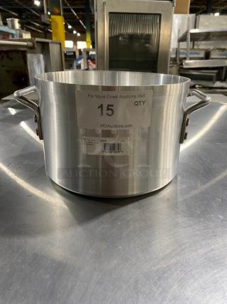 Large stainless steel stock pot with side handles, labeled "15 QTY" with auction details, in used condition.