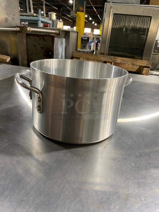 Large stainless steel cooking pot with dual handles, reflective finish, in excellent condition, no visible markings.