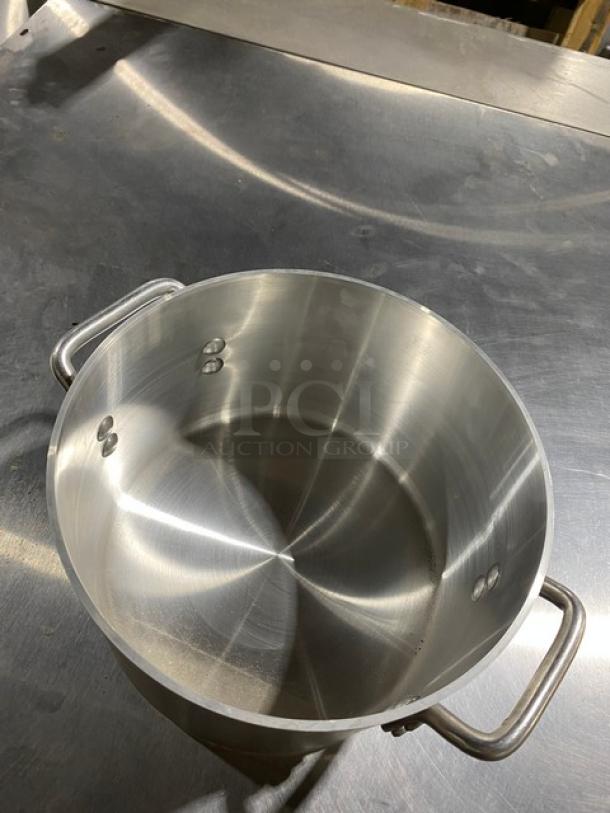 Stainless steel stockpot with dual handles, polished finish, in excellent condition. No visible markings or labels.