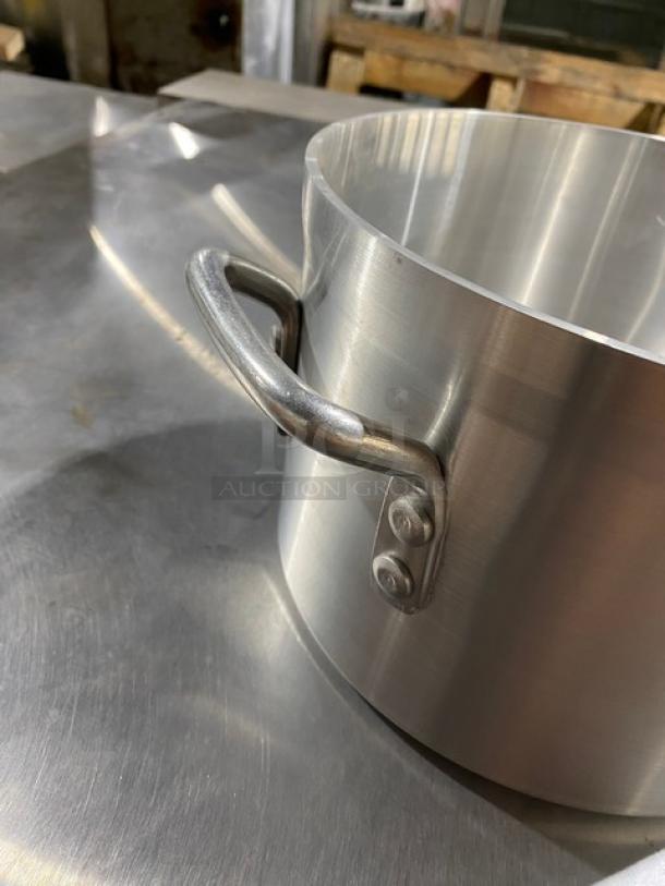 Stainless steel pot with sturdy riveted handle, polished finish, excellent condition, ideal for professional kitchen use.