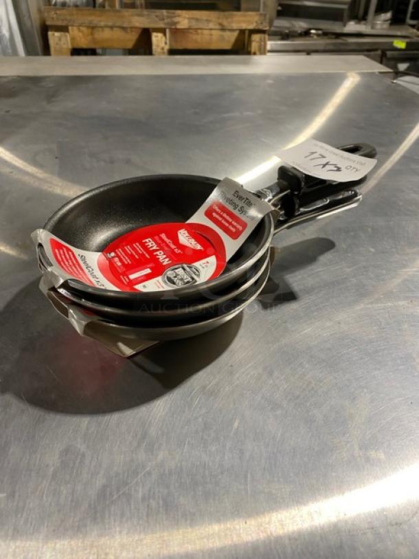 Set of three nonstick T-Fal frying pans, brand new with tags indicating even heat distribution and ergonomic handles.