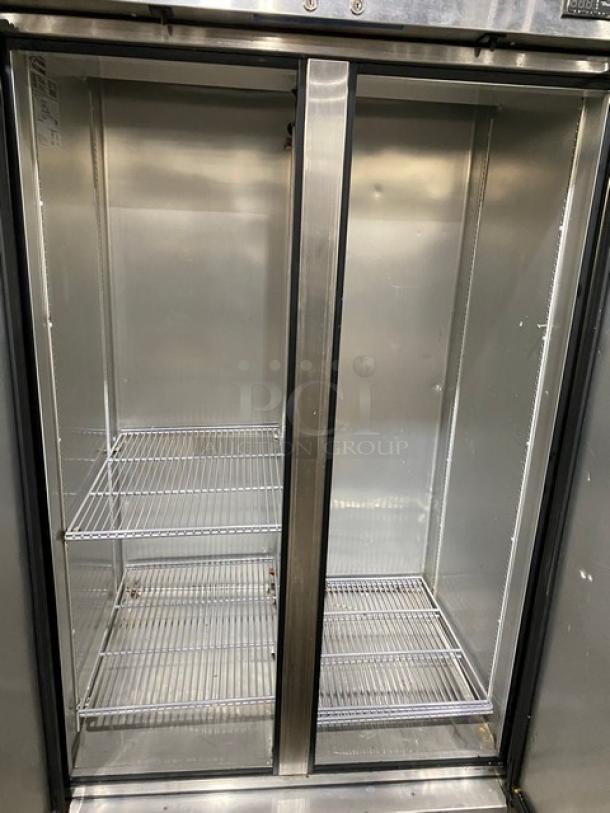 Commercial stainless steel double-door refrigerator with wire shelving, in good condition. Ideal for restaurant use.