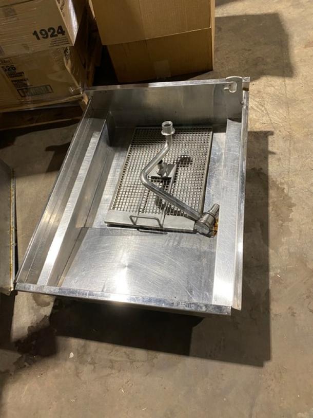 Large industrial metal sink with attached faucet and drain grid, in good condition, suitable for heavy-duty use.