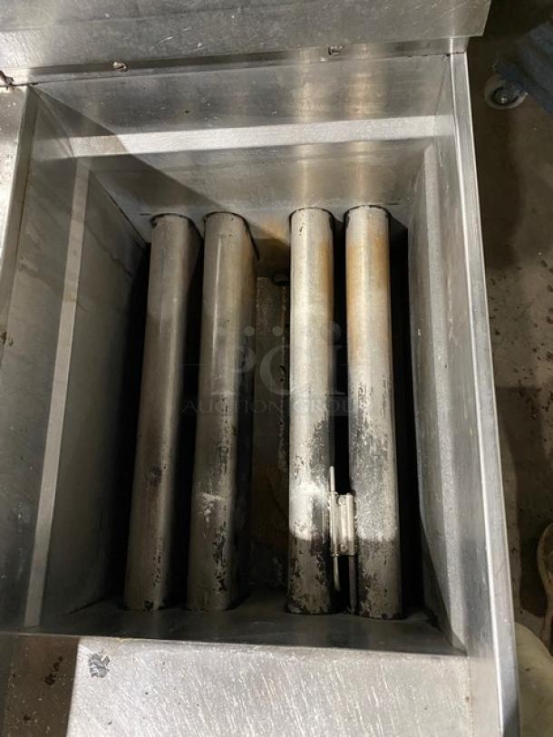 Industrial metal filtration unit with four cylindrical filters, showing wear and oxidation. Suitable for heavy-duty applications.