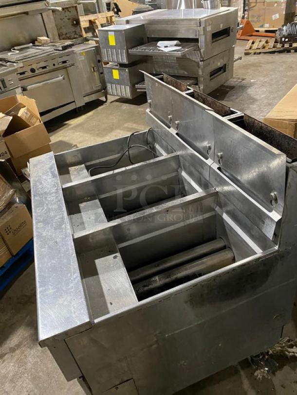 Commercial stainless steel deep fryer with four compartments in fair condition. No visible brand markings.
