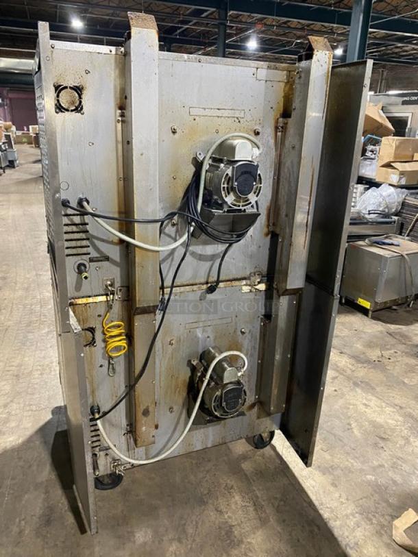 Industrial stainless steel equipment with mounted motors and wiring, showing signs of rust and wear.