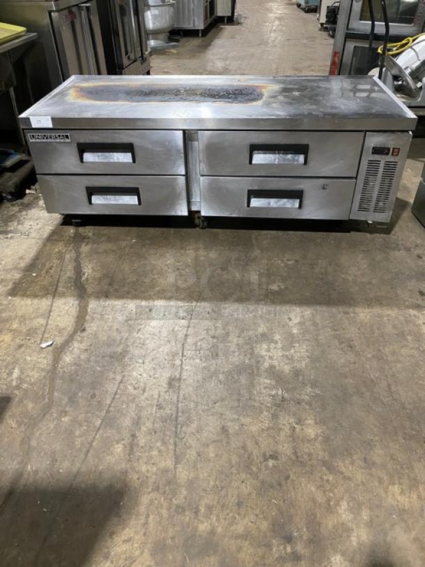 Stainless steel prep table with two double-drawer refrigeration units. Visible wear on surface. Brand: True.