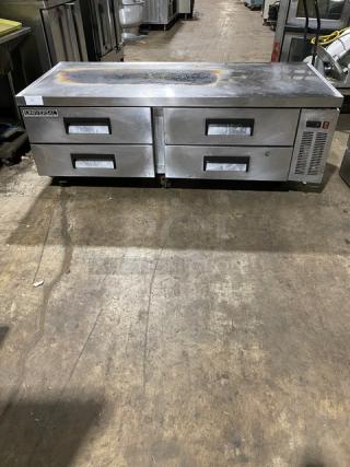 Stainless steel prep table with two double-drawer refrigeration units. Visible wear on surface. Brand: True.