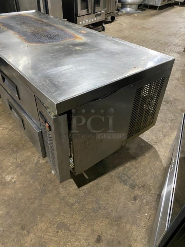 Commercial stainless steel refrigerated prep table with drawers, showing surface wear and oxidation, used condition.