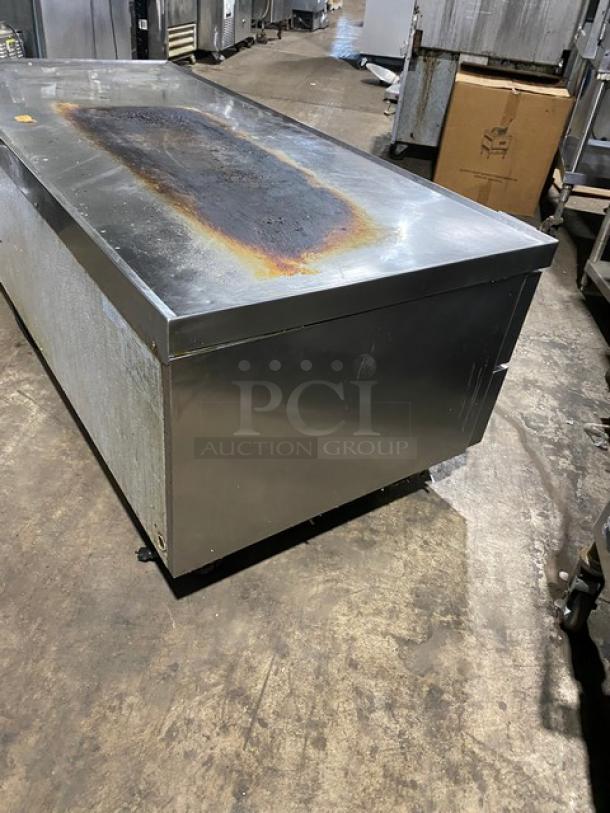 Large stainless steel commercial cooler with significant rust on the top surface, in used condition.