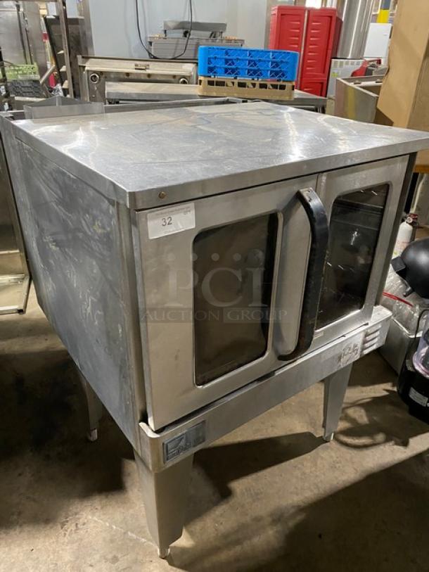 Commercial stainless steel convection oven, used condition, double glass doors, label reads "32," sturdy metal legs.