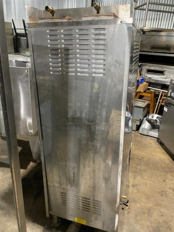 Commercial stainless steel oven on wheels, vented panels, top controls, showing moderate wear, suitable for restaurant use.