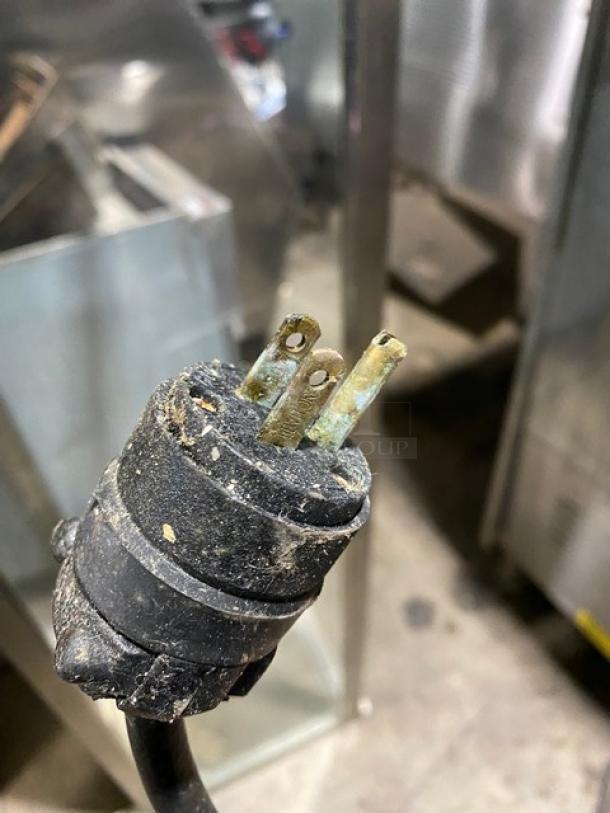 Worn electrical plug with three prongs, showing oxidation and dirt. Ideal for repair or parts.