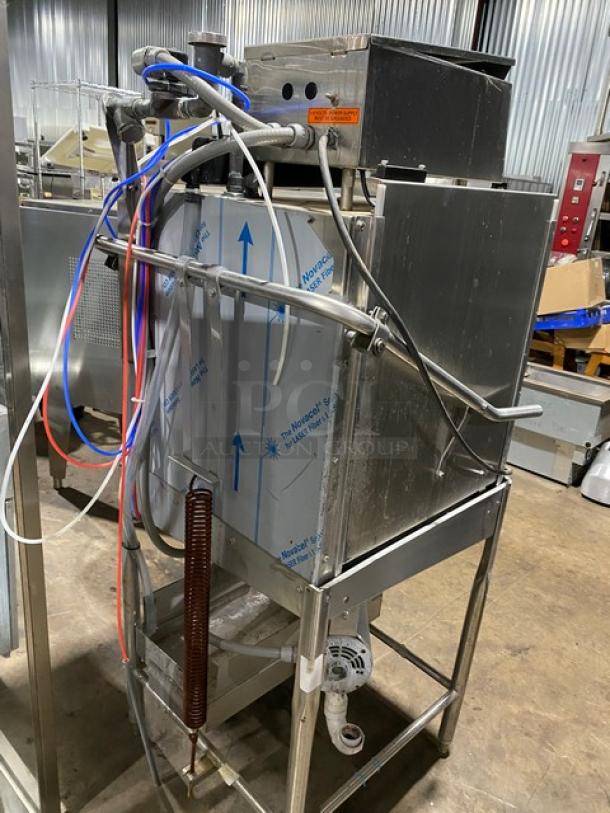 Commercial dishwasher with metal frame and hoses, used condition. "Advance Tabco" label visible. Industrial kitchen equipment.