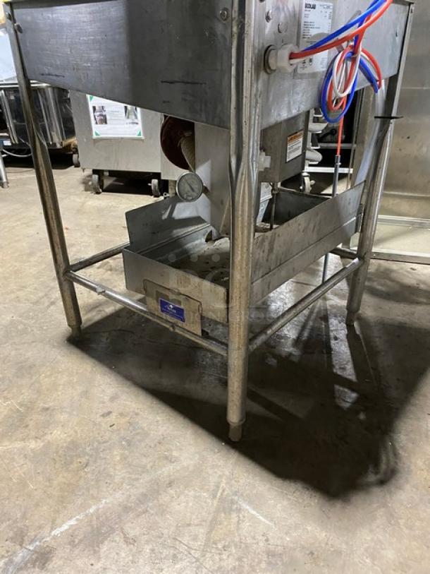 Commercial stainless steel food processing equipment with attached gauge and colorful cables. Features a label indicating specifications.