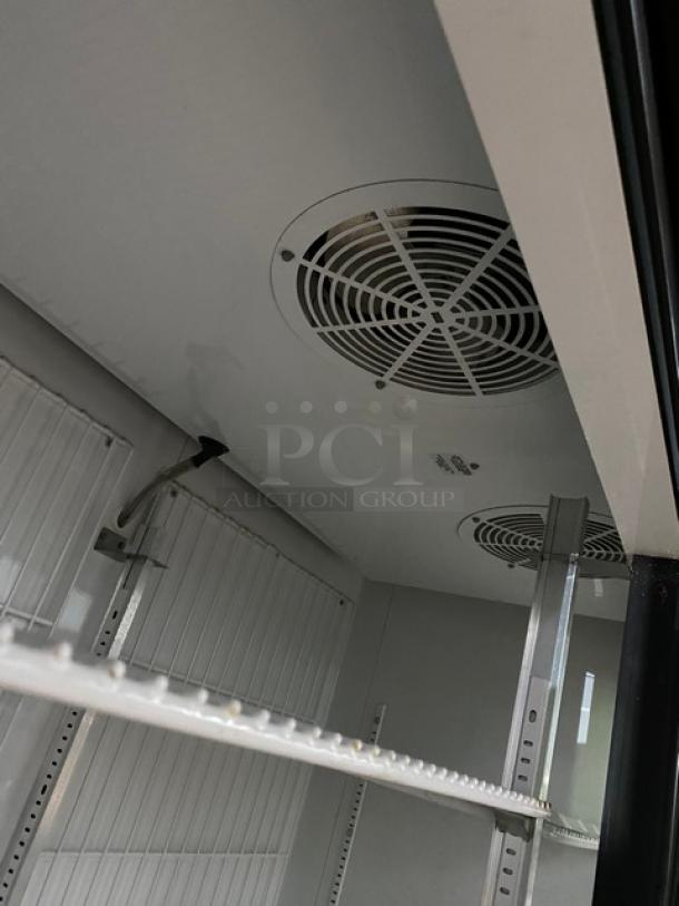 Commercial refrigerator interior with adjustable shelving and cooling vents, in good condition. No visible labels or markings.