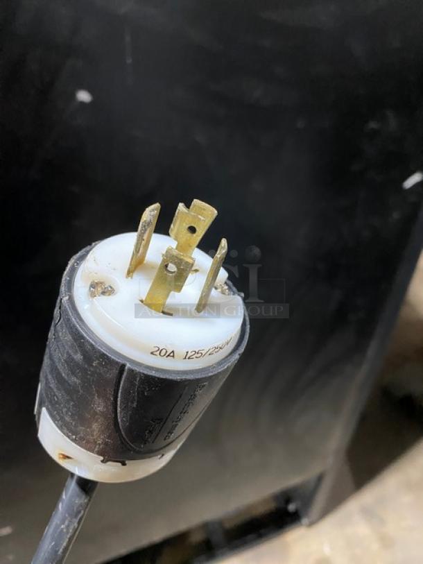 20A 125/250V electrical plug, black and white casing, gold prongs, in good condition, for heavy-duty appliances.