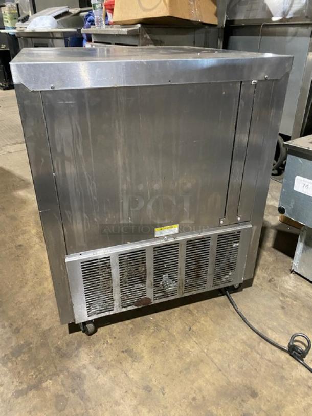 Commercial stainless steel ice machine with ventilation panel and visible power cord. Used condition, suitable for kitchens.