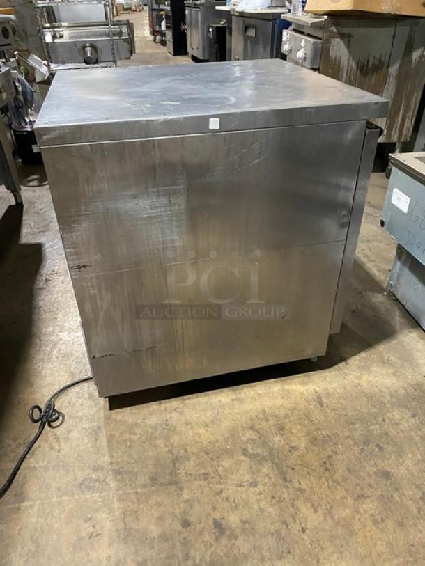 Stainless steel commercial refrigerator, used condition, single door, visible scratches, model and brand not visible.