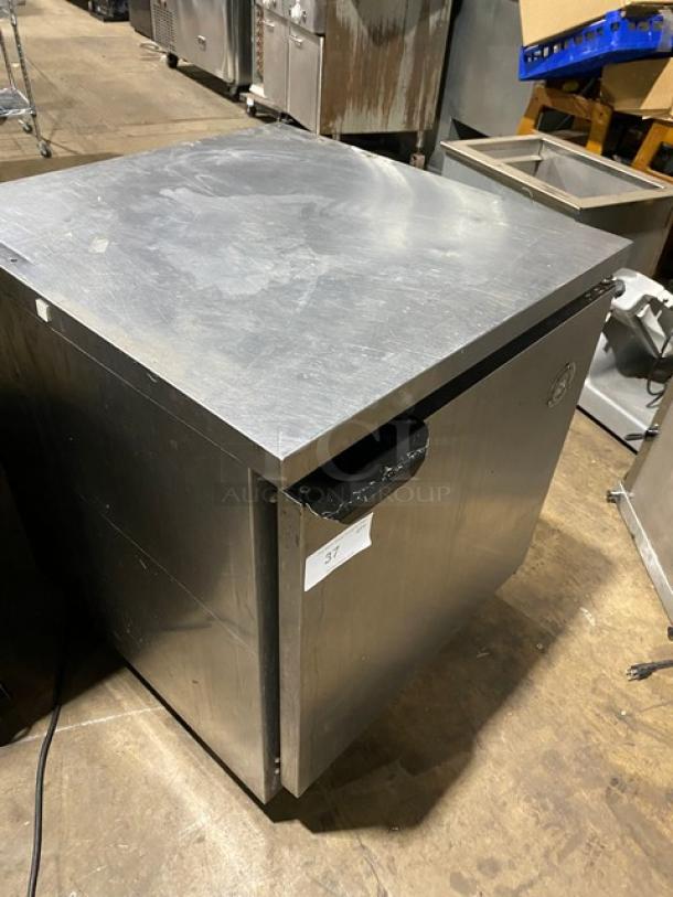 Stainless steel commercial undercounter freezer, moderate wear, model number not visible, with sticker labeled "37."