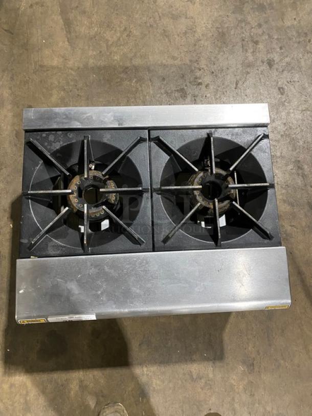Double burner commercial stovetop, cast iron burners, used condition with visible wear; steel body, sturdy construction.