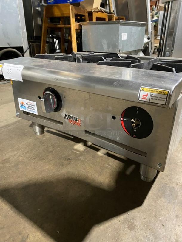 APW Wyott commercial countertop range with dual burners, stainless steel, visible control knobs, warning labels, used condition.