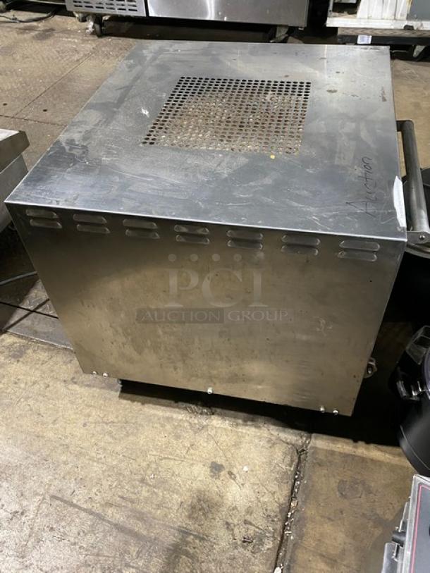 Industrial stainless steel machine, vented top, moderate wear, tagged with "Auction" marking.