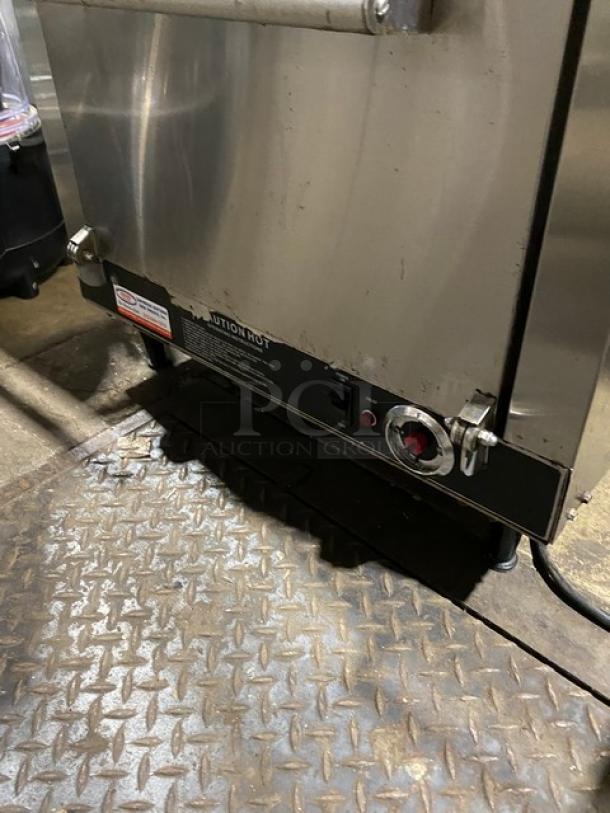 Commercial stainless steel oven with visible control knob and temperature settings. Used condition. Safety label present.