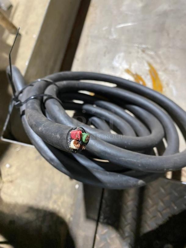 Coiled black industrial cable with exposed wire ends, showing red and green wiring. Appears in used condition.