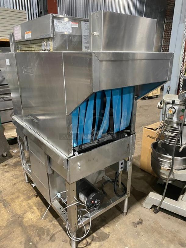 Stainless steel commercial conveyor dishwasher with control panel, visible wiring, and blue curtain strips in good condition.