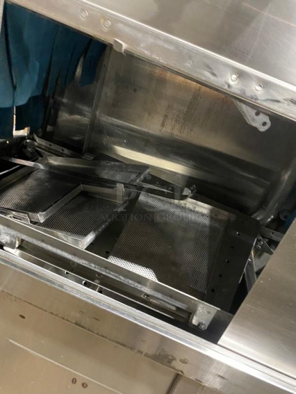 Industrial stainless steel machine component with multiple perforated metal trays, used and in functional condition.