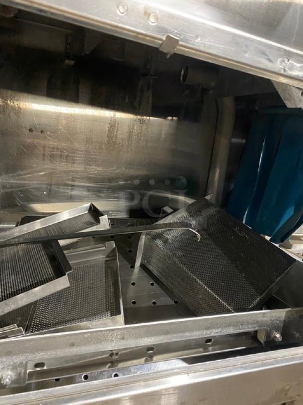 Industrial stainless steel perforated trays in used condition, suitable for commercial kitchen or equipment.