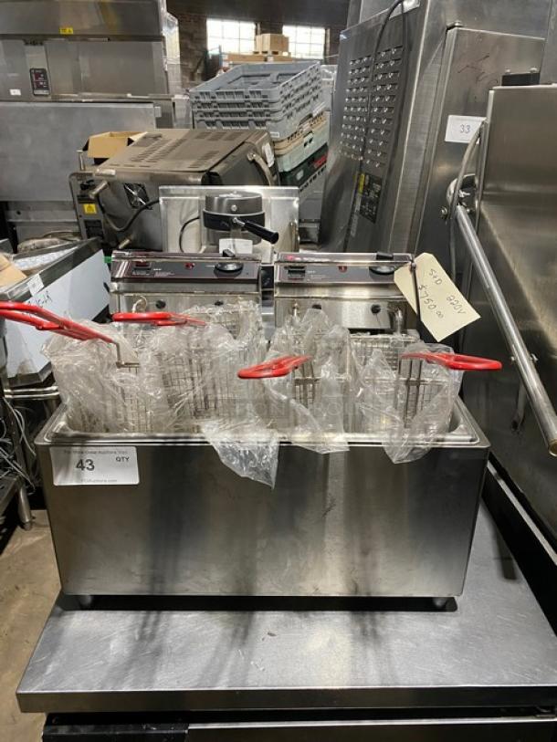 Twin deep fryer with dual baskets, red handles, stainless steel, good condition. Label shows specifications and lot number.