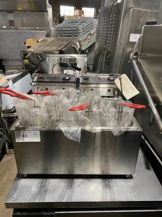 Twin deep fryer with dual baskets, red handles, stainless steel, good condition. Label shows specifications and lot number.