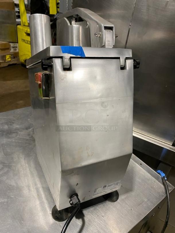 Commercial metal food processor, heavy-duty, visible power switch, minor wear, label indicates electrical specifications.