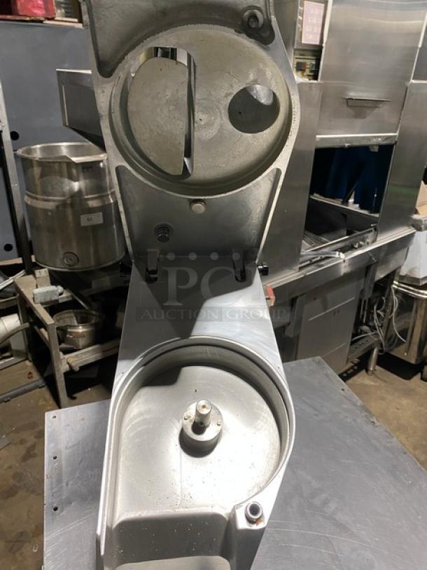 Commercial ice cream machine base, stainless steel, showing mixing chamber, used condition, visible wear marks.