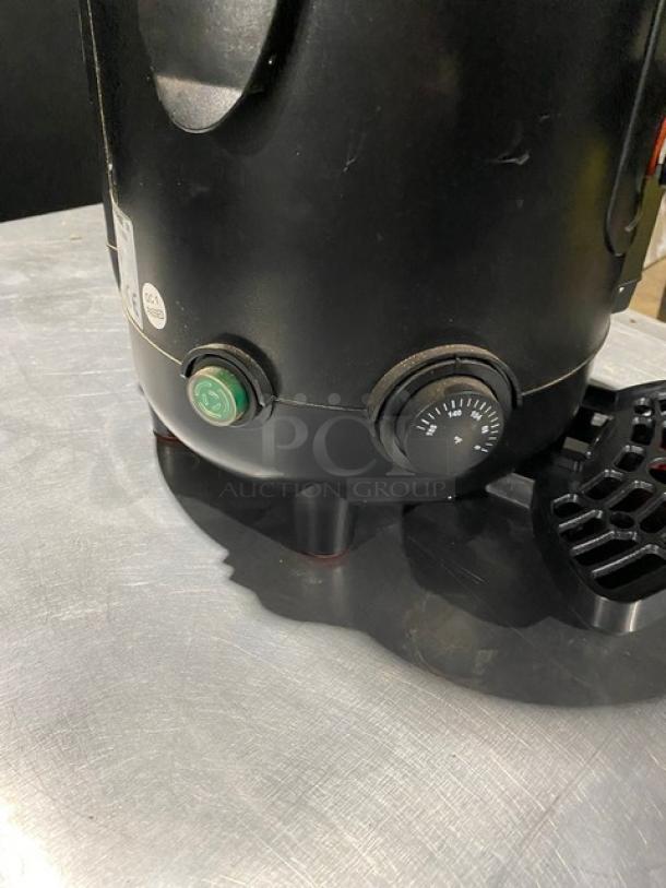 Black industrial equipment base with control dials. Includes power and timer dials, safety certification label visible.