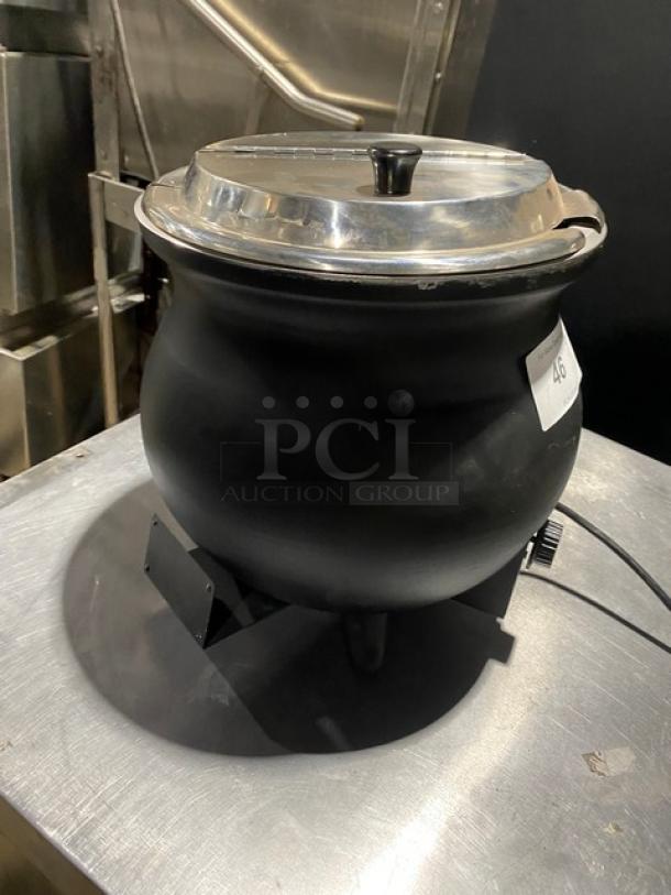 Black electric soup kettle with stainless steel lid, used condition, visible dial for temperature control. Label marked "46."
