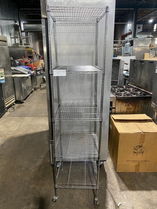 Tall metal storage rack with five wire shelves, number tag "47" attached. Used condition, suitable for industrial use.